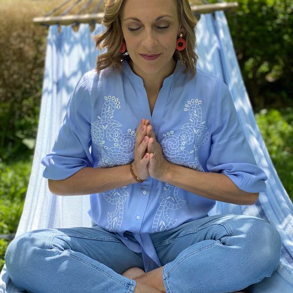 A person sitting in a cross-legged position focusing on breathing.