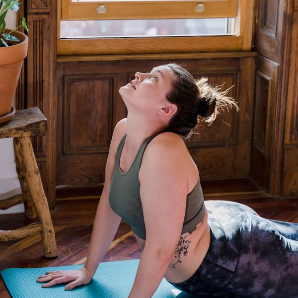 Yoga mat and wooden floor detail with soft morning sunlight shadows.